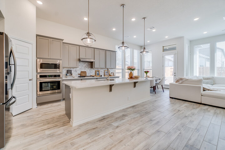 Bright modern open-concept kitchen and living area in an empty home, showing why regular home watch visits matter for coastal properties